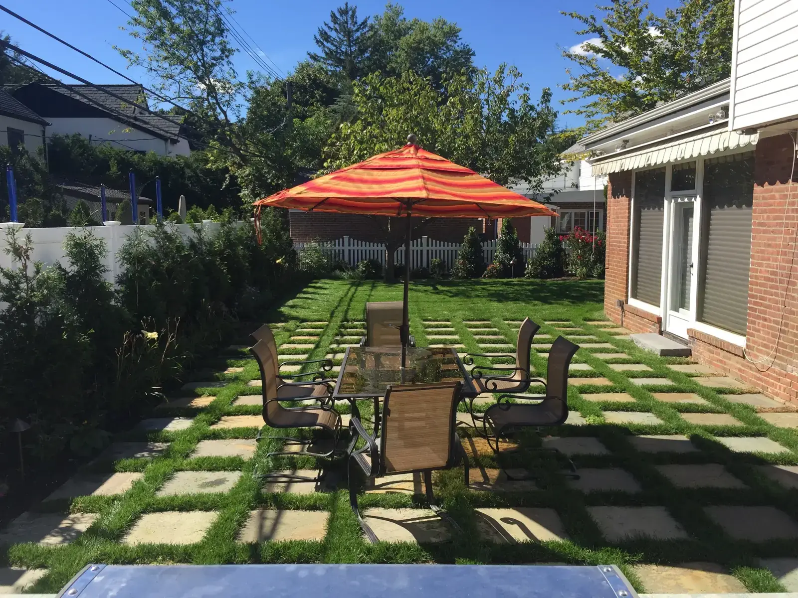 Paver and lawn patio with a dining terrace