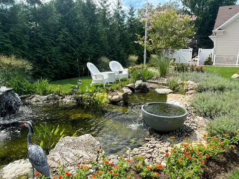 Pond with waterfall rock ledge in Long Island, by Scott Anderson Design.