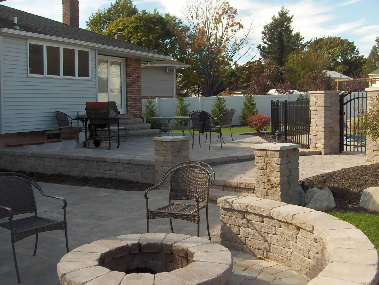 Raised bluestone patio with a stone firepit and seat wall built by Scott Anderson Design on Long Island